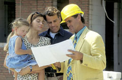 A builder showing plans to a unit owner