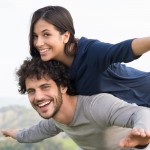 Young woman smiling and piggy backing her boyfriend