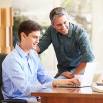 Father and son working on a laptop