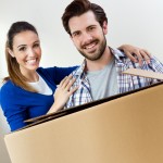 Young, smiling couple with a moving box