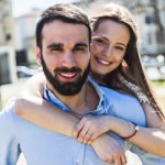 Young couple smiling and standing together in the sun