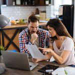 Two couple working out a plan in their kitchen on how to buy in the competitive market