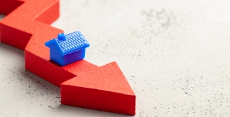 Wooden blocks arranged in a staircase pattern with white percentage symbols and upward arrows, representing a rise in interest rates or growth metrics.