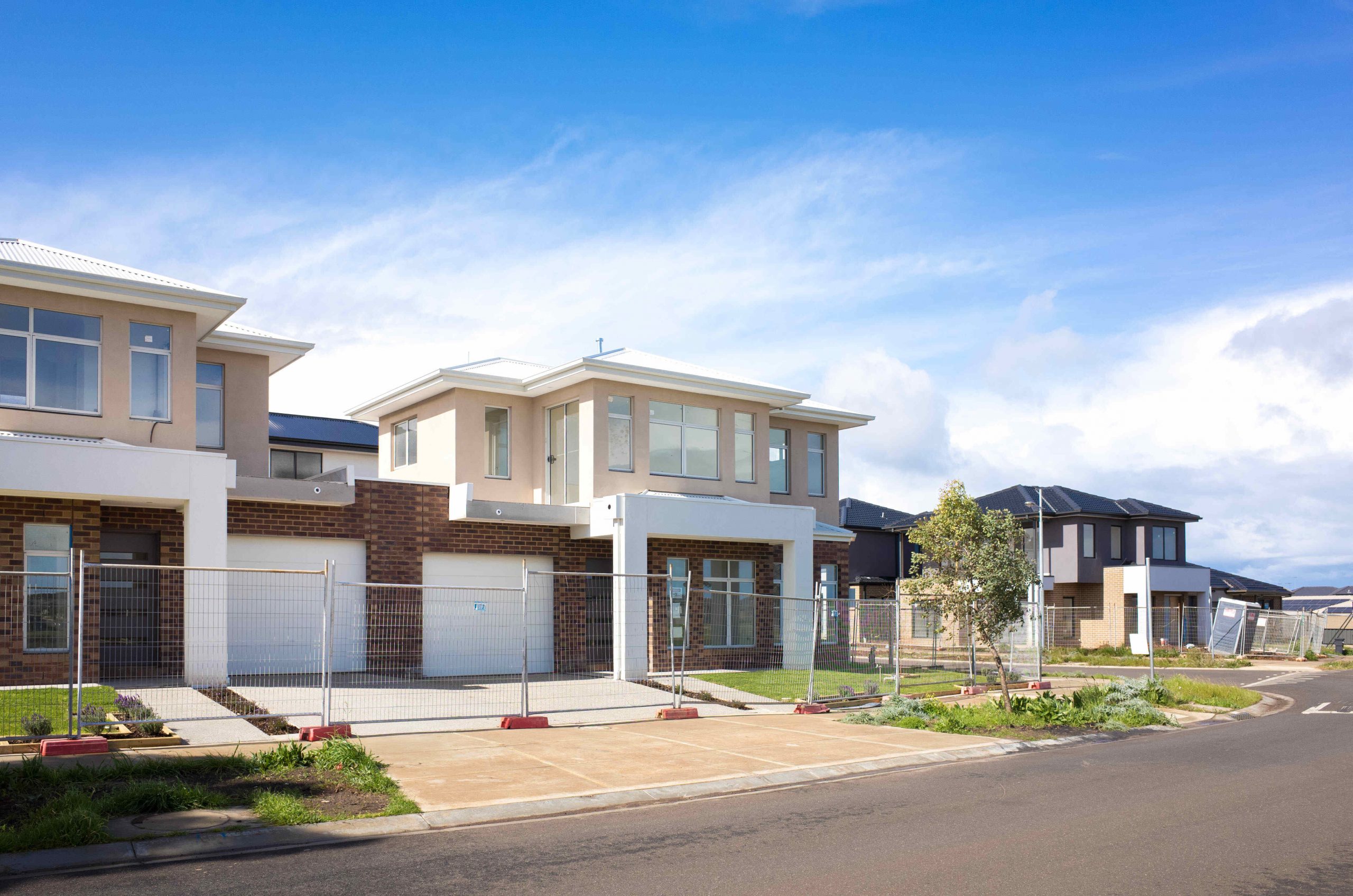 Two similar looking houses attached together by each of their garage