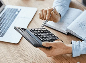 A hand punches the calculator button to find out the repayment on his mortgage