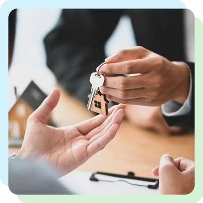 A person handing over house keys to another person in a real estate transaction.