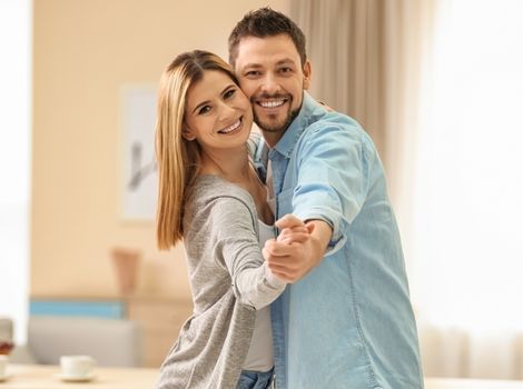 Happy couple dancing at home